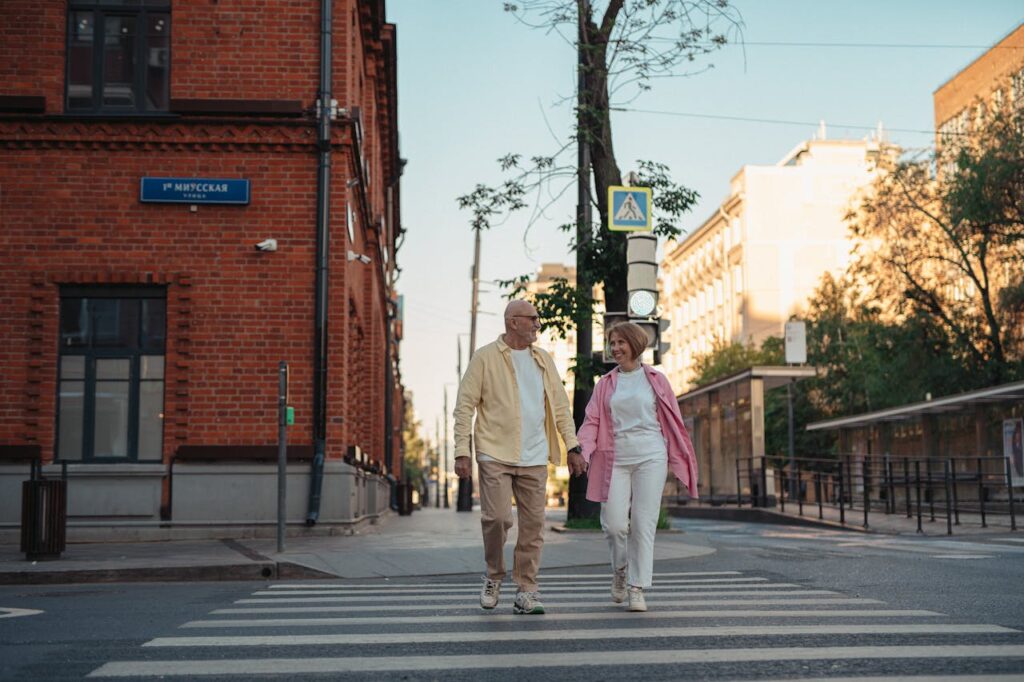 happy-elderly-couple-holding-hands-while-crossing-on-the-pedestrian-lane-8972253 Happy Elderly Couple Holding Hands while Crossing on the Pedestrian Lane